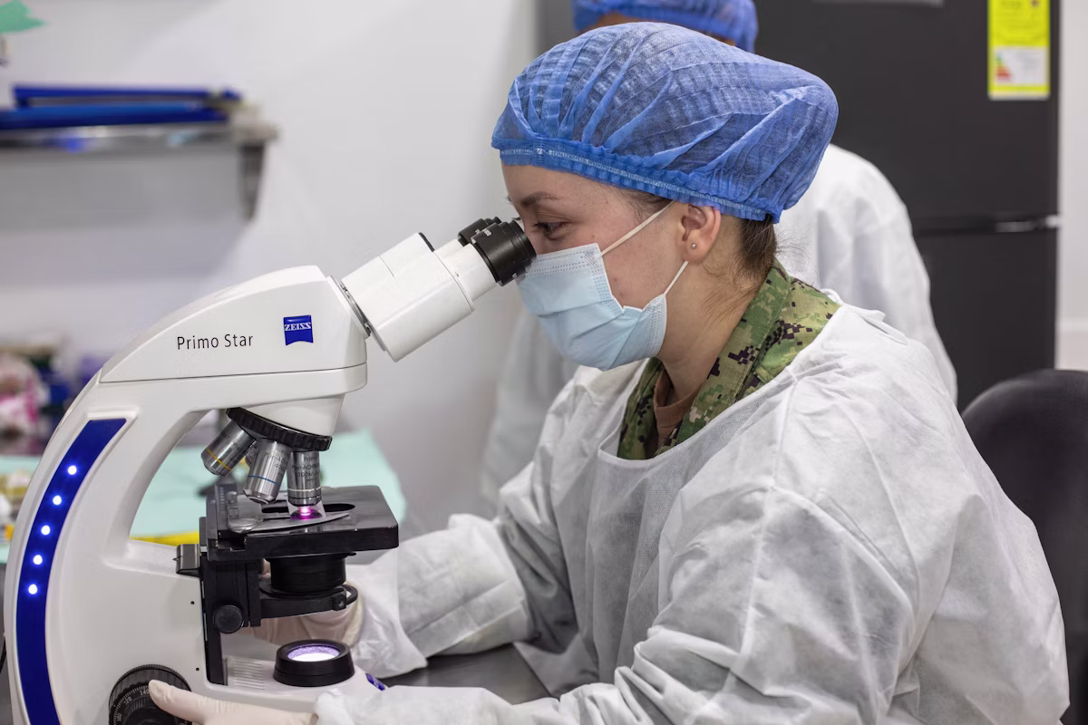 Laboratory scientist examining a sample under a microscope